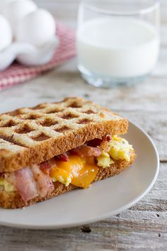 a waffle sandwich with ham and eggs on it