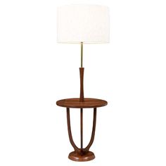 a wooden table lamp with a white shade on the base and a wood stand underneath it