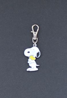 a keychain with a cartoon character holding a flower in it's mouth