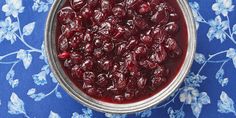 a bowl filled with cranberry sauce on top of a blue table cloth