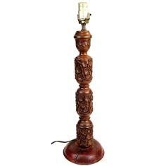 a wooden table lamp with a candle on the top and carvings on the bottom,