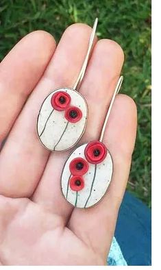 pair of earrings with red and white flowers in the shape of an eyeball on them