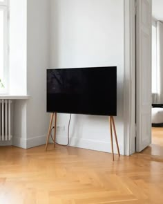 a flat screen tv sitting on top of a wooden stand