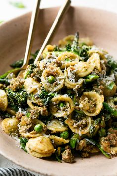 a bowl filled with pasta and vegetables on top of a table