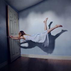 a woman is jumping in the air with her legs spread out and arms stretched out