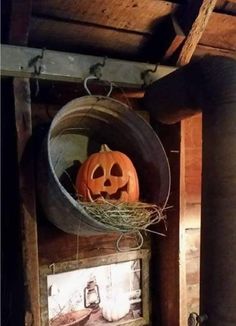 a pumpkin sitting in a bucket on top of a shelf