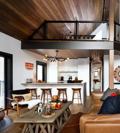 a living room filled with furniture next to a kitchen