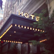 the hotel sign is lit up for guests to enjoy it's own night time