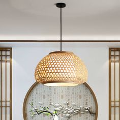 a living room filled with furniture and a vase on top of a wooden table under a light fixture