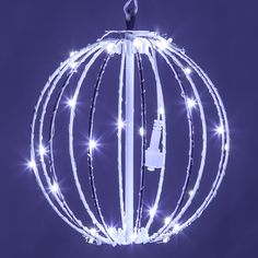 a lighted ball ornament hanging from a hook on a string with white lights