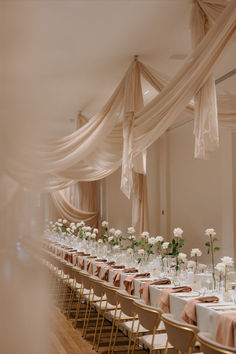 the tables are set up with white flowers and place settings for guests to sit at