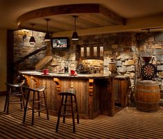 a bar with stools in front of a stone wall