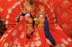 two dolls are dressed in red and gold