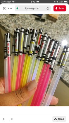 a person holding several different colored pens in their hand