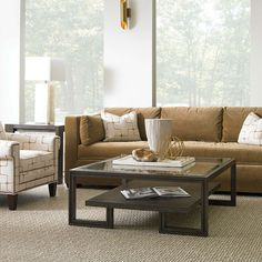 a living room with two couches and a coffee table in front of large windows