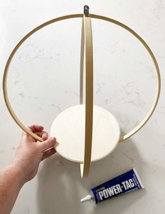 a person is holding a piece of paper near a circular object on a counter top