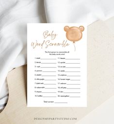 the baby word scramble game is shown on top of a white sheet with gold foil