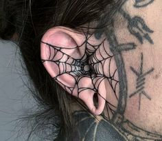 a woman with spider web tattoos on her neck and behind the ear is a clock