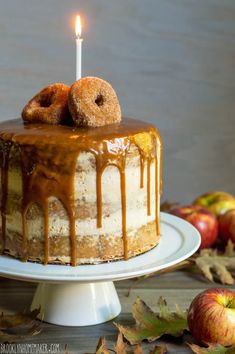 a cake with caramel icing and two donuts on top sitting on a plate