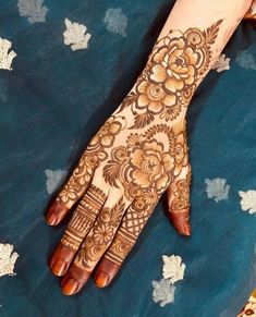 a woman's hand is decorated with hennap and flower designs on it