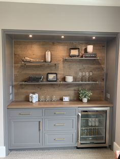 a kitchen with gray cabinets and shelves filled with wine glasses