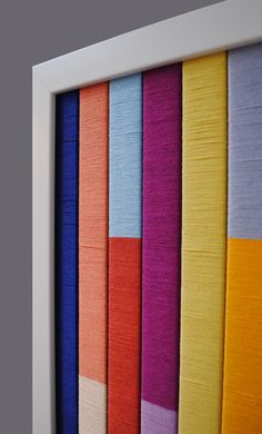 a white frame with multicolored fabric in it