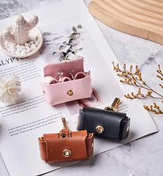 four small purses sitting on top of an open book