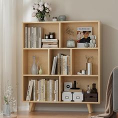 a bookshelf filled with lots of books in a living room next to a window