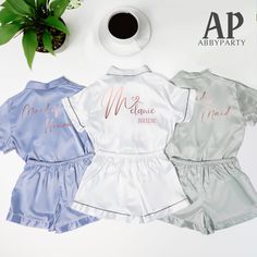 three bridesmaids'pajamas are sitting on a table next to a cup of coffee