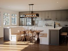 a kitchen with an island, table and chairs next to a stove top oven in it