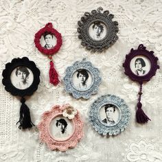 six small frames with photos on them are sitting on a lace tablecloth, one has a tassel around the edge