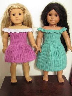 two dolls standing next to each other on a table