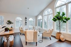 a living room filled with furniture and lots of windows next to a wooden floored floor