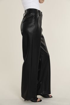 Elevate your professional outfits (or even just your everyday looks) with an edgy wardrobe staple like our Faux Leather Wide Leg Trouser Pants. Tailored to perfection, these wide legged trousers offer a relaxed yet polished vibe, ideal for curating a smart casual look. The sleek faux leather material lends a modern edge, while the wide leg cut ensures a comfortable, airy feel. Pair these with a crisp blouse or a casual tee to create versatile looks that transition effortlessly from office hours Sleek Straight Leg Leather Pants For Formal Occasions, Sleek Formal Straight Leg Leather Pants, Sleek Dress Pants For Night Out In Fall, Chic Wide-leg Leather Pants For Workwear, Sleek Wide Leg Leather Pants For Night Out, Sleek Wide Leg Workwear Pants Full Length, Elegant Wide Leg Leather Pants For Night Out, Trendy Wide Leg Dress Pants For Formal Occasions, Sleek Leather Straight Pants For Office