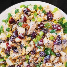 a white plate topped with chicken salad and cranberries