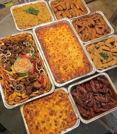 many trays of food are arranged on a glass table in front of each other