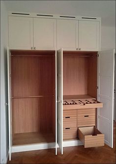 an empty room with two open closets and some drawers in the middle of it