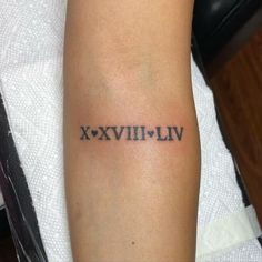 a tattoo with roman numerals on the arm