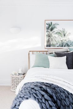 a bedroom with white walls and black and white bedding