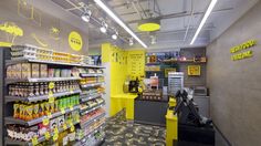 the inside of a grocery store with yellow and black accents on the walls, along with shelves full of food