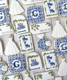 decorated cookies with blue and white designs are arranged on a tablecloth that says villa olviero