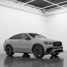 the new mercedes gle is shown in an empty room with white walls and black rims