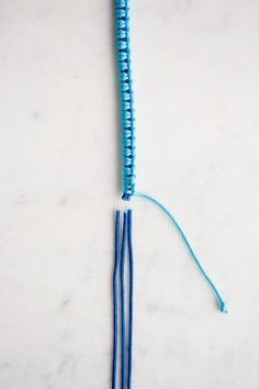 a blue string with two ends on a white surface