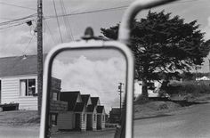 the reflection of houses in a rear view mirror