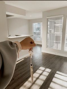 a person's hand holding a key in an empty room