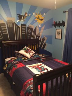 a bed room with a neatly made bed and batman wallpapers on the walls