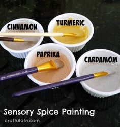 four cups with different types of paint and spoons in them that say turmeric, paprika, carbamom