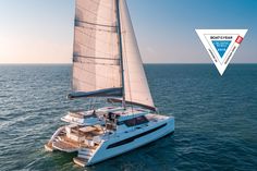 a catamaran sailing in the ocean on a sunny day with blue sky and water