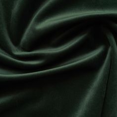 a close up view of a dark green velvet fabric with very soft folds and wrinkles