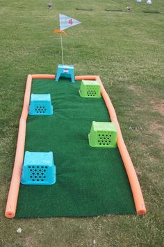 an inflatable golf course is set up on the grass with orange and blue markers